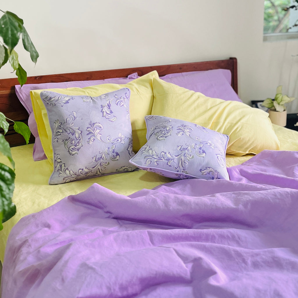 Luxury lavender cushion cover featuring intricate floral scrolls, perfect for elegant home decor.