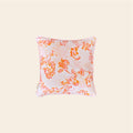 A vibrant orange and pink cushion cover made from hemp fabric, featuring an intricate floral scrollwork pattern on a light base, centered against a clean off-white background.