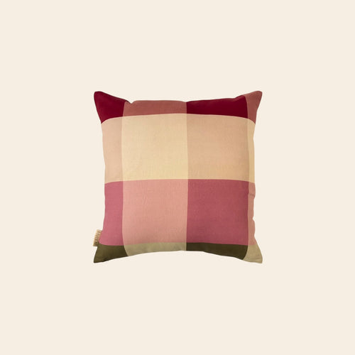 A square cusion cover made from hemp fabric with a soft checkered pattern in pink, beige, and maroon on a plain background.